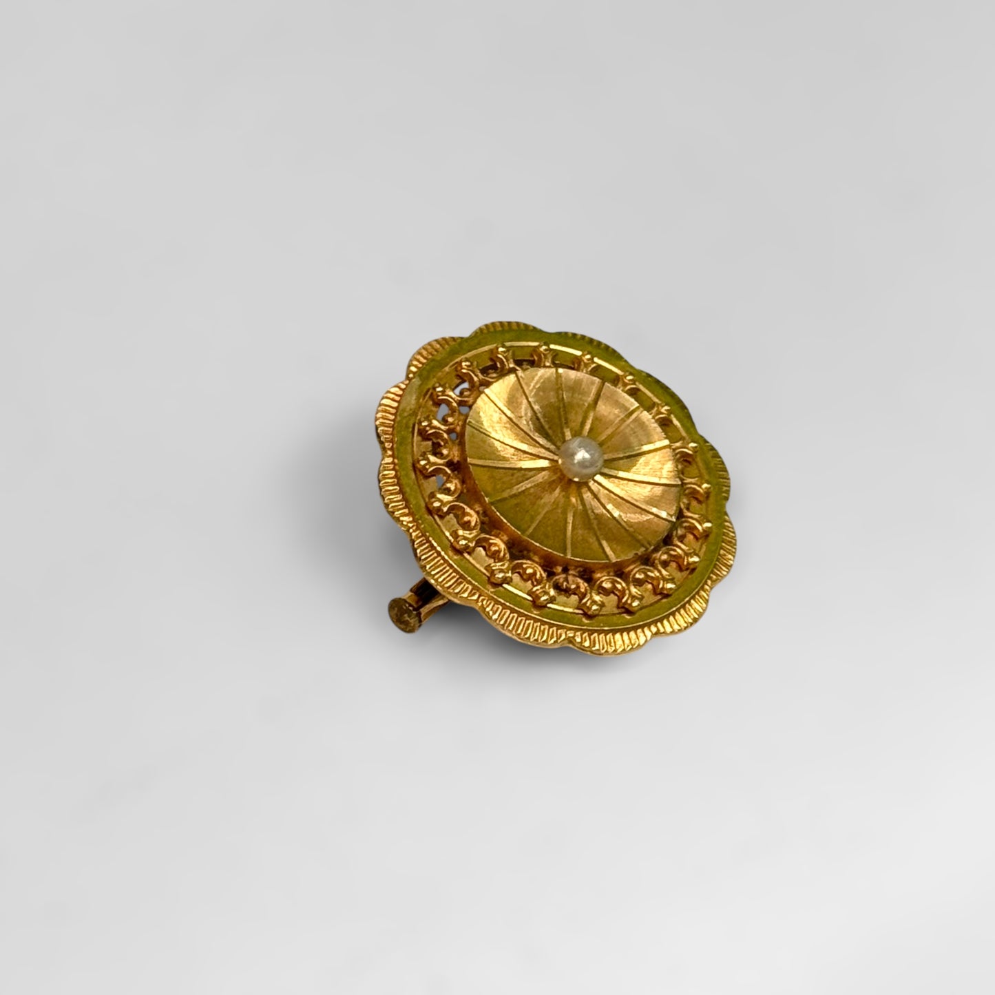 Round golden brooch with pearl