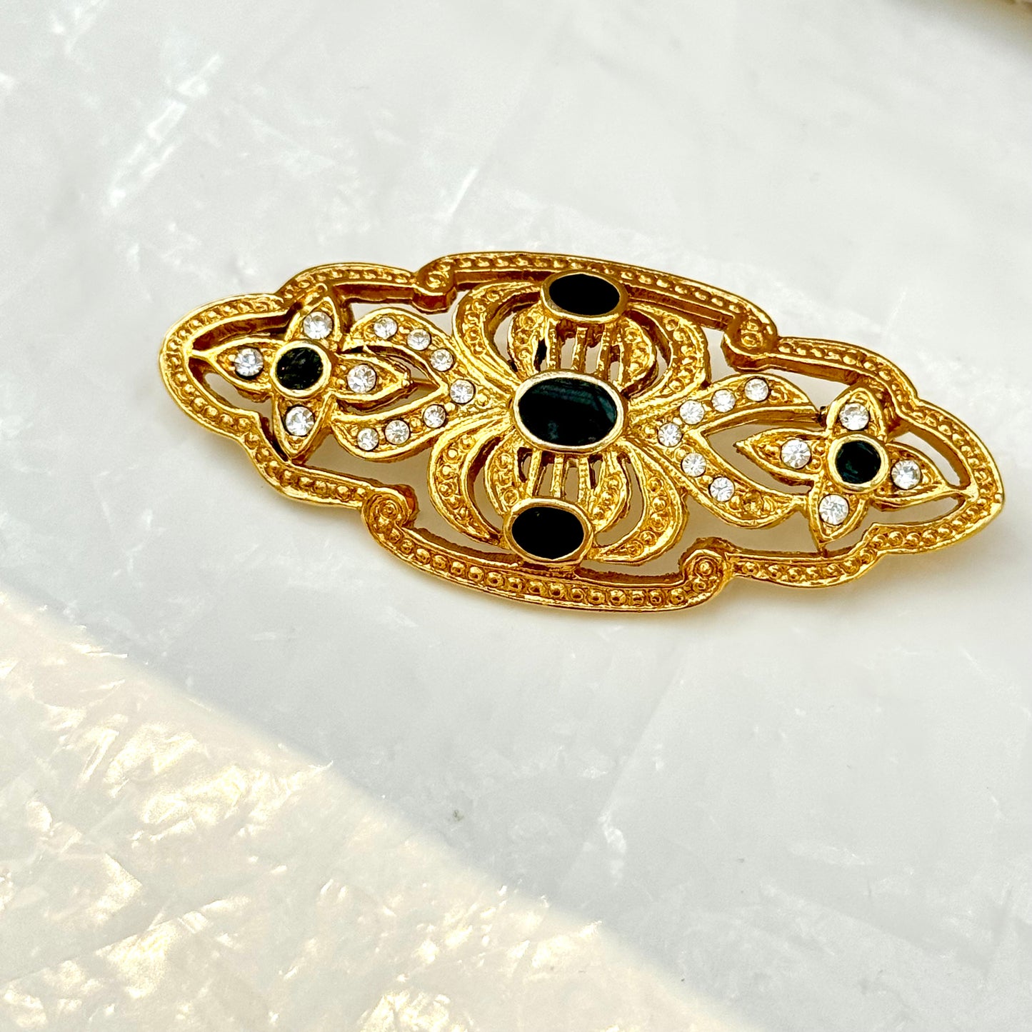 Gold and black brooch with detailed arabesques 2