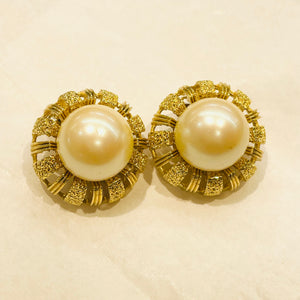 Round white pearl earrings with openwork golden rim