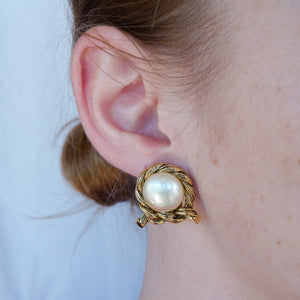Round white pearl earrings slightly marked and encircled with a knotted golden cord Vintages from GIGI PARIS